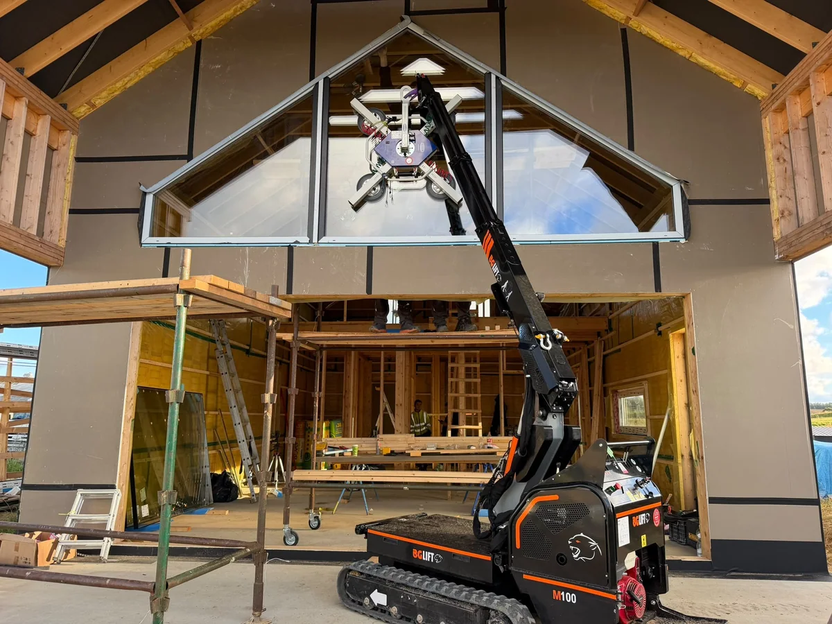 Mini żuraw BG Lift M100 osadza trójkątną szybę w szczycie domu